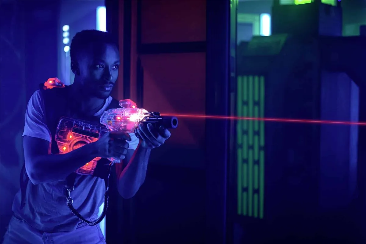 Joueur de laser game visant dans une salle éclairée aux néons
